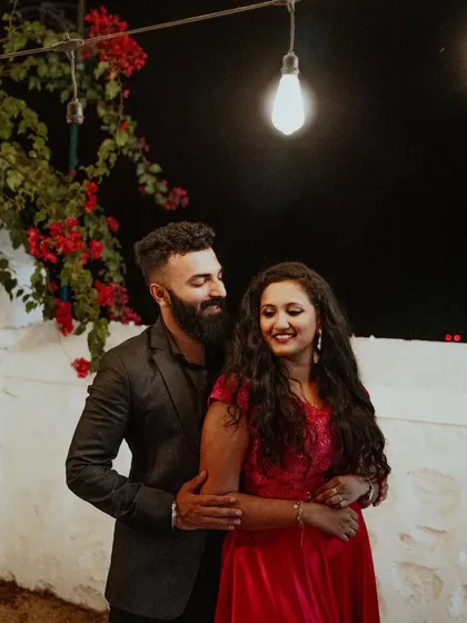 A sweet and intimate portrait of a couple under a single light, creating a moody and romantic atmosphere for their pre-wedding photos.
