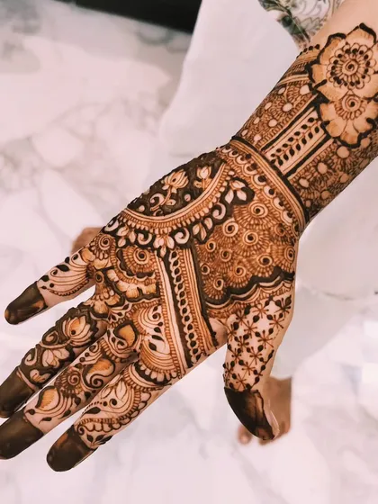 A different angle of the floral-themed bridal mehendi. The design covers the entire palm and extends up the arm, perfect for a bride who loves floral art.