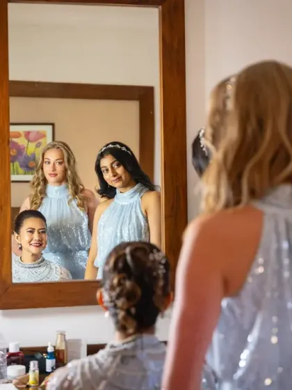 A creative shot of the wife and her daughters getting ready, captured in the reflection of a mirror.