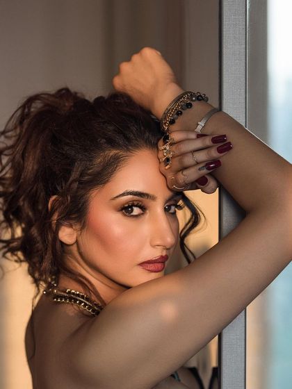 A close-up portrait using soft, natural window light. This intimate shot focuses on the model's expression and the delicate details of her accessories.