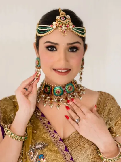The client's full traditional look, with her hair in a neat bun. This allows her elaborate headpiece and jewelry to be the main focus.