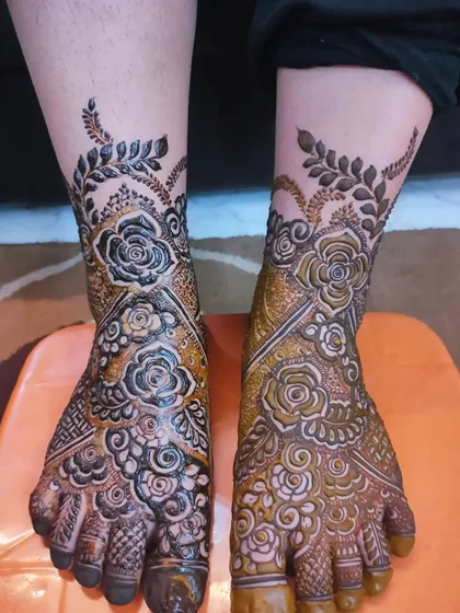 A beautiful feet design for bride Kulsum, with one foot showing the fresh paste and the other showing the start of the stain.