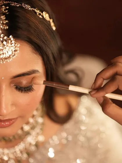 A close-up of the artistry. This behind-the-scenes shot shows the delicate application of eyeshadow, a crucial step in creating a soft and blended look.