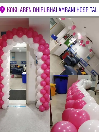 A pink and white balloon arch inside the Kokilaben Dhirubhai Ambani Hospital. This shows how a simple arch can brighten up an indoor hallway for a special event or celebration.
