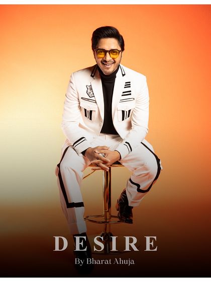 Command the room in monochrome magic. This seated portrait showcases the bold lines and sleek cuts of the white and black striped suit.