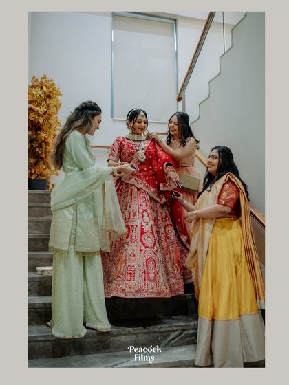 The bride gets help from her bridesmaids on the stairs. A lovely candid moment of friendship and support on the wedding day.
