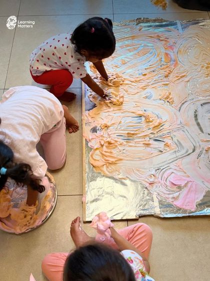 This large-scale floor painting with shaving foam is a full-body art engagement. Children use their hands, arms, and even feet to explore texture and color, learning about mixing and movement in a wonderfully messy and liberating way.