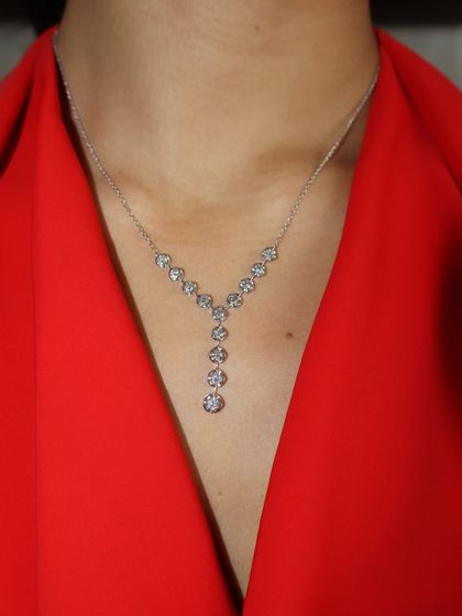 A close-up of the Y-shaped diamond lariat necklace, showing the brilliant-cut diamonds that create a simple yet captivating sparkle.