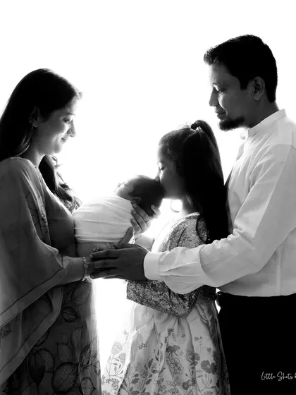 Your first portrait as a new family is a treasure. I always encourage parents and siblings to join the session to capture the complete story of love and connection. This beautiful high-contrast, black and white family portrait freezes a moment of pure adoration.