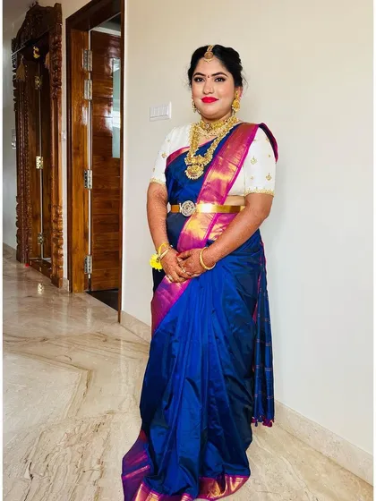A full-length view of the bangle ceremony look. The contrast of the white blouse with the blue saree is stunning, and the makeup ties it all together.