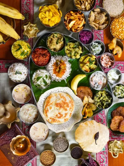 A magnificent Onam Sadhya feast served on a banana leaf, captured from directly above. This flatlay showcases the incredible variety and vibrant colors of the traditional Kerala celebration meal.