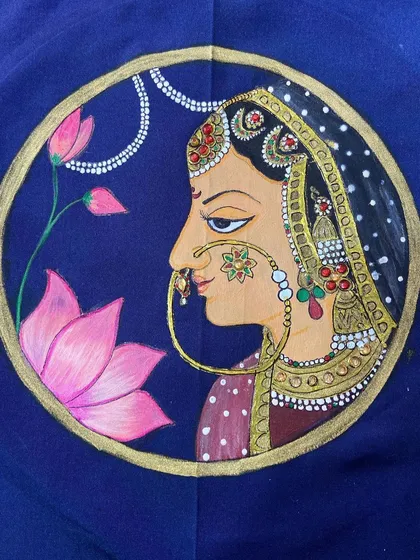 We guide our students in mastering traditional art forms like this intricate Thanjavur painting. This piece, created by a student, showcases the rich color and detail we teach in our textile art workshops.