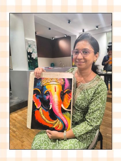 A student proudly presents her vibrant, pop-art style painting of Lord Ganesha, showcasing a bold use of color and confident brushwork.