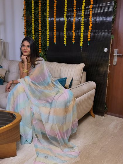 Relaxing at home during Diwali. This shot shows the beautiful drape and subtle shimmer of the pastel-colored saree against our festive home decor.