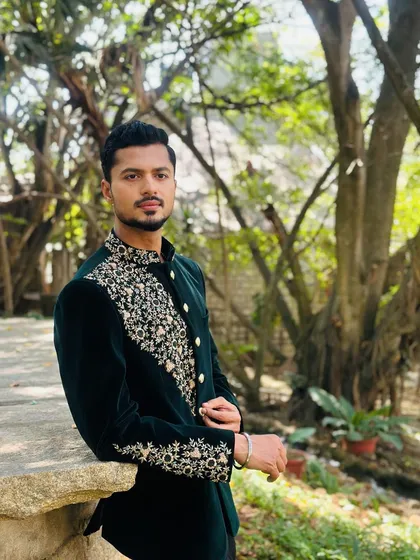A calm and collected pose in a beautiful outdoor setting, modeling a custom-fit ethnic jacket.