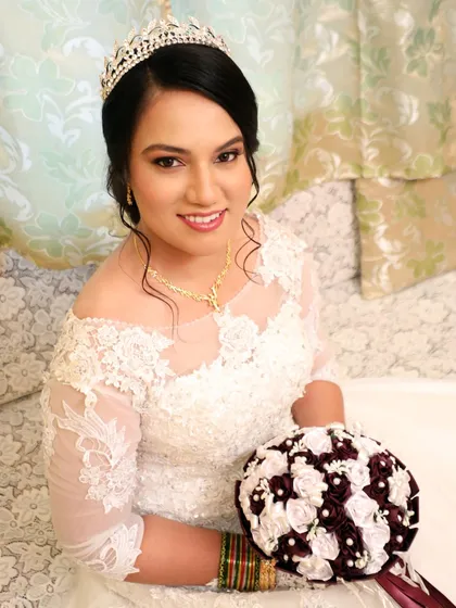 A portrait of a beautiful bride with a classic updo and a sparkling tiara. Her makeup features a soft smokey eye and a neutral pink lip, a timeless combination.