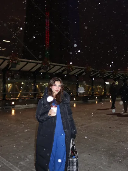 A full-length view of my winter outfit during a snowfall, showing how I style for cold, snowy nights in the city.