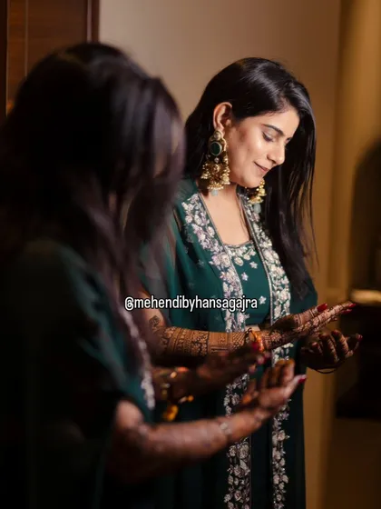 The most beautiful moment is when a bride sees her story reflected in her hands. This candid shot captures that feeling of quiet joy and anticipation, which is the true essence of bridal mehendi.