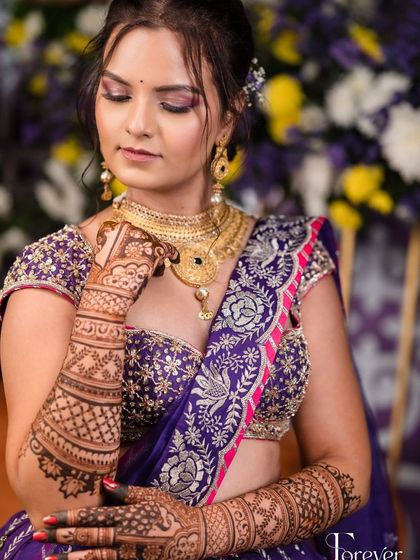 A close-up of the bride's elegant pose, showing off her sangeet mehendi and jewelry.