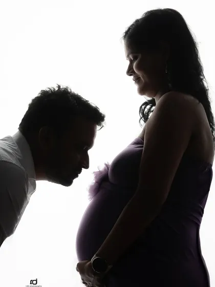 A tender silhouette of a partner kissing the baby bump. This artistic shot is a beautiful and emotional way to capture the bond between the dad-to-be and the baby.