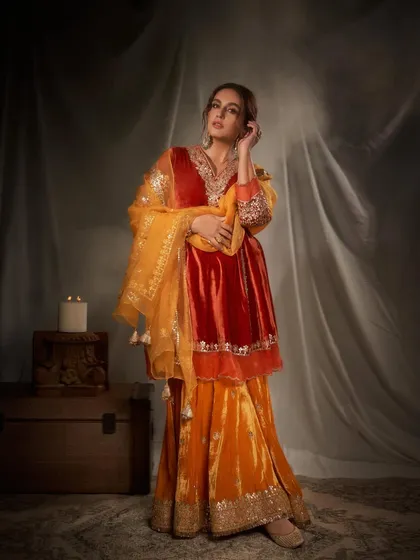 This look captures pure festive opulence. I chose a rich, jewel-toned velvet sharara set in shades of orange and red, accessorized with regal gold jewelry to create a look that is both traditional and incredibly glamorous for any grand celebration.