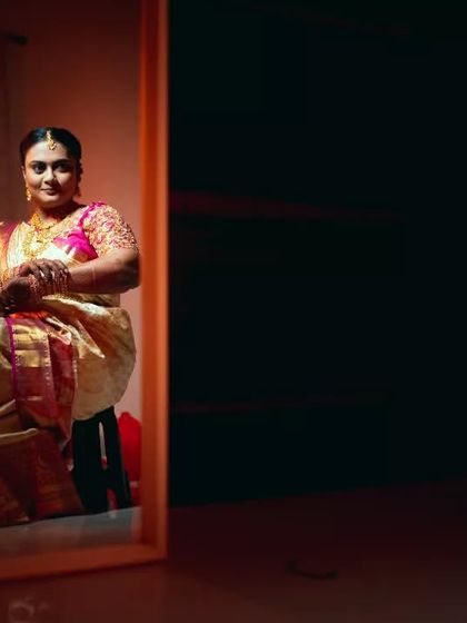 A creative bridal portrait using a mirror and dramatic lighting to create a sense of depth and introspection.