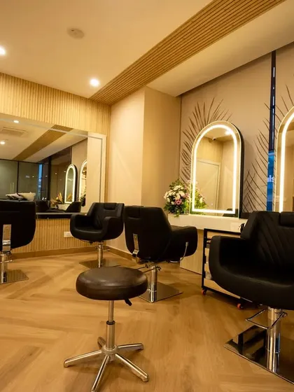 We designed the styling stations to feel both personal and professional. The combination of warm wood-patterned flooring, sleek black chairs, and custom mirrors with integrated lighting creates a cohesive and upscale environment that reflects the salon's brand.