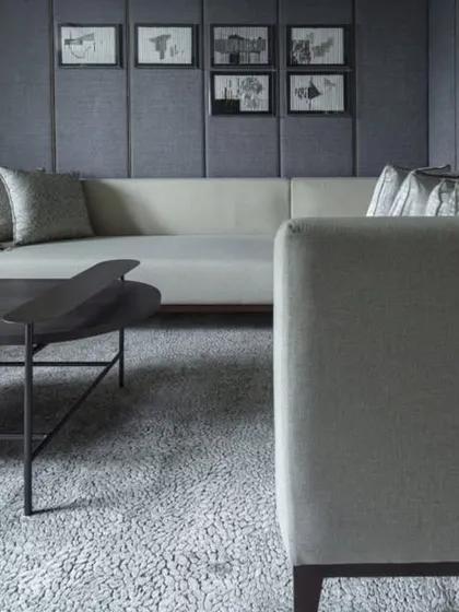 The home theatre at the Jor Bagh Residence, designed for comfort and cinematic experience. The room features plush, deep sofas and sound-absorbent paneled walls in a muted, dark palette.