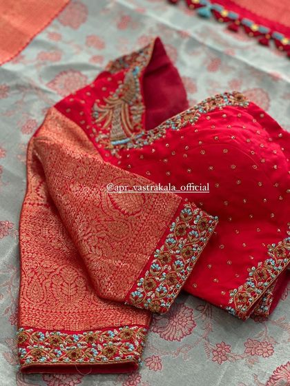 A red blouse with brocade sleeves and delicate bird embroidery.