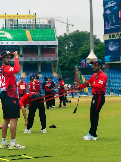The team working with resistance bands during a warm-up. This helps activate the key muscles needed for explosive cricketing actions.