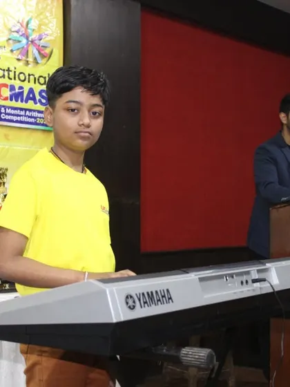 A talented student performs on the keyboard during the NLC Awards Ceremony, showcasing the diverse talents of our UCMAS kids.