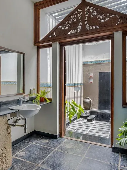 The Vasishta suite's bathroom, with its stone-carved vanity and view to a private courtyard, is a perfect example of our blend of rustic and refined.