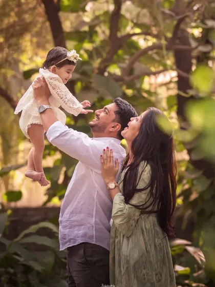 A father lifts his daughter towards the sky in a beautiful outdoor setting. This shot is full of movement, joy, and the magic of a parent's love.