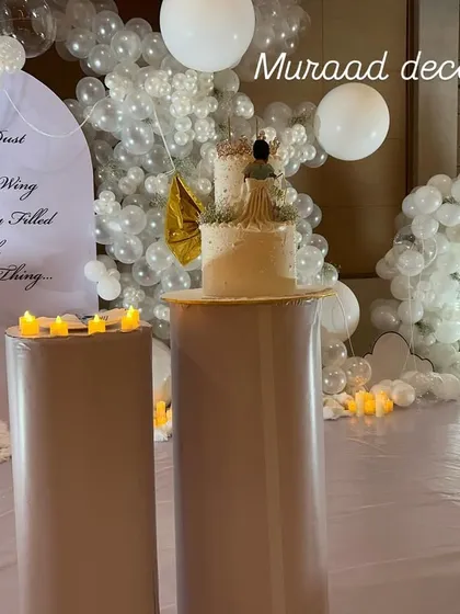 A clearer view of the cake and backdrop for the royal first birthday. The all-white balloon decor and fairy-like details create a truly magical and ethereal atmosphere for the celebration.