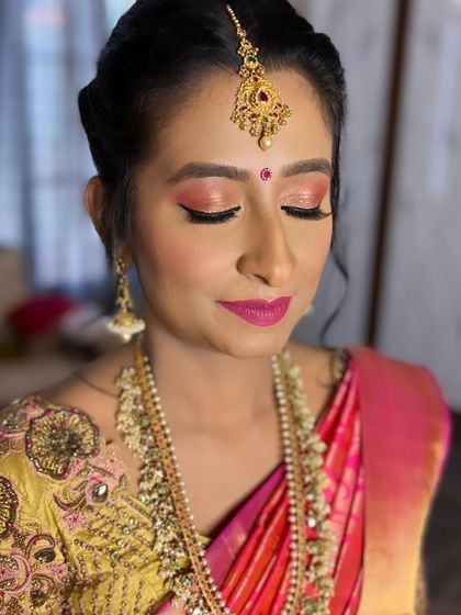 A close-up of the Muhurtham makeup, showing the shimmer on the eyelids and the beautiful pink lip color that complements her embroidered blouse.