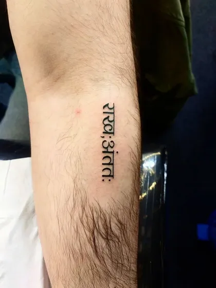 A simple yet profound script tattoo on the forearm. The clean Devanagari font ensures the message is clear and impactful.
