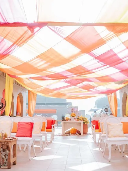 The ceiling of this walkway was decorated with a beautiful weave of orange, yellow, and pink drapes, creating a colorful canopy that bathed the space in warm, joyful light.