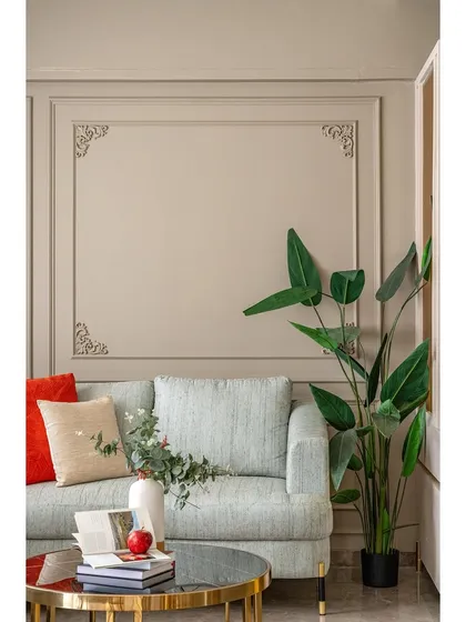 Detail of the neoclassical wall moulding and a plush sofa corner. We use architectural details like these to add character and a sense of established elegance to our interior designs.