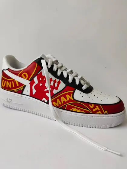 Another shot of the Manchester United Air Force 1s. The design wraps around the entire shoe, making a statement from every angle. Perfect for a true fan.