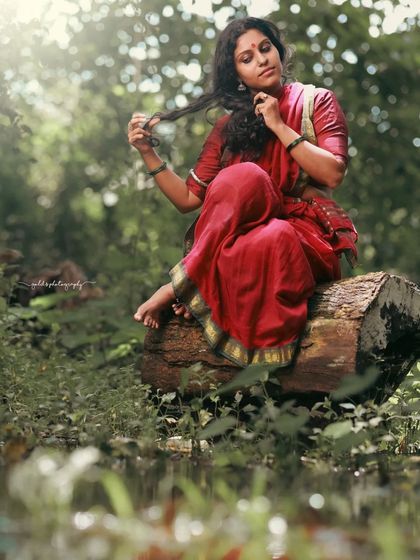 A rustic, village-themed series inspired by the movie 'Kanthara'. The model is styled in a simple red saree, captured in a natural, watery landscape to evoke a sense of raw, earthy beauty.
