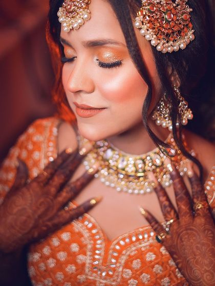 A close-up shot focusing on the bride's makeup and jewelry. The soft focus and warm tones give this image a dreamy quality.