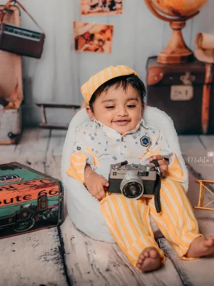 Posing with his camera, this little one is capturing memories of his own.