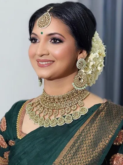 A model showcasing a simple and elegant look with a green Kundan choker. This rental set is perfect for a wedding guest or bridesmaid look.