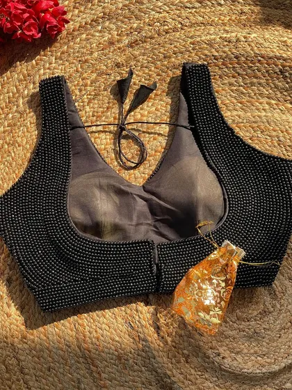 My handcrafted pearl ready-to-wear blouse in black, featuring a deep U-neck and back hook closure.