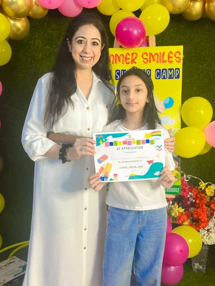 This young participant proudly holds her certificate after a fun-filled summer camp. We will miss her energy and creativity.