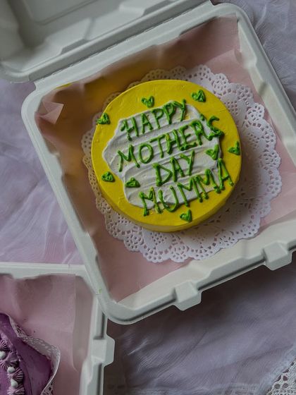 A bright and sunny yellow bento cake with a sweet "Happy Mother's Day Mumma" message. We love creating these colorful mini cakes for your special occasions.
