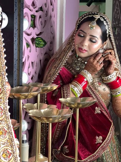A candid shot of the bride getting ready, adjusting her earring. The mirror reflection adds a nice artistic touch.