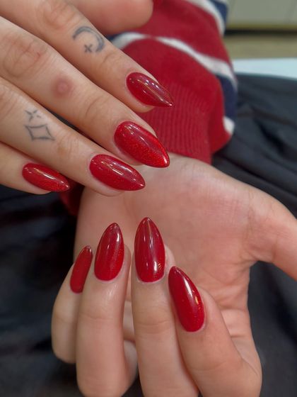 A close-up showing the flawless application and shine of this classic red holiday manicure.