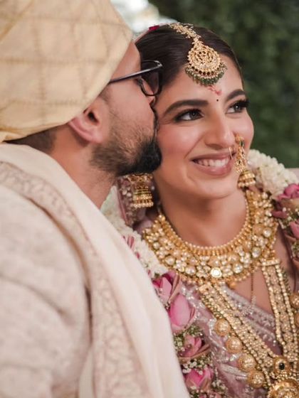 A tender moment as the groom gives his bride a kiss on the cheek, capturing the affection and love between them.