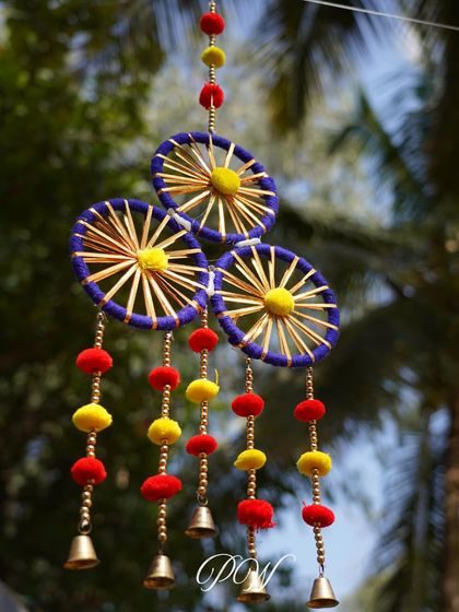 A close-up of a colorful hanging decoration, featuring pom-poms and bells. These small, handcrafted details add a personal and charming touch to the decor.